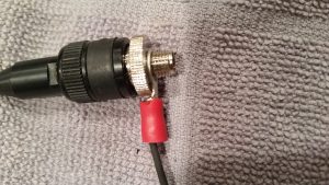 The antenna connector is shown in a close up with the rat tail O connector with wire slid into the ground of the antenna.